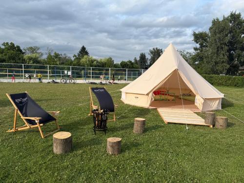 a tent and two chairs and a table and chairs at Čerčanská Koupadla - glampingové stany in Benešov