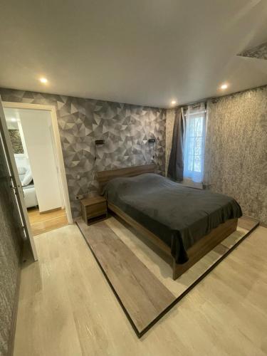 une chambre avec un grand lit et un mur en pierre dans l'établissement Charmante Apartment, à La Chaussée-Saint-Victor