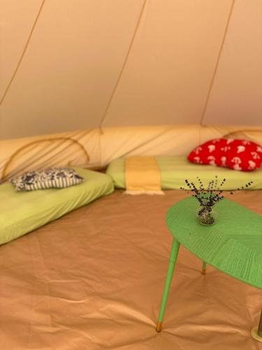 a room with two beds in a tent with a table at Čerčanská Koupadla - glampingové stany in Benešov
