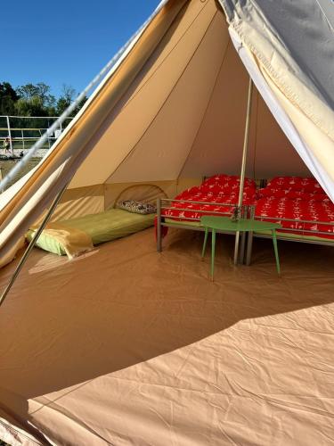 a tent with two beds and a table in it at Čerčanská Koupadla - glampingové stany in Benešov