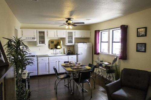 eine Küche mit Tisch und Stühlen und einem Kühlschrank in der Unterkunft The 1950s Retro Riverside Cottage in Dardanelle