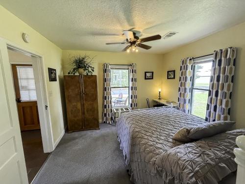 ein Schlafzimmer mit einem Bett und einem Deckenventilator in der Unterkunft The 1950s Retro Riverside Cottage in Dardanelle