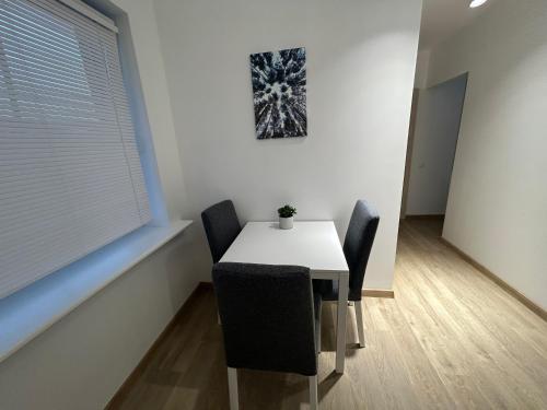 une salle à manger avec une table et des chaises blanches dans l'établissement Kastycio 6a, à Palanga