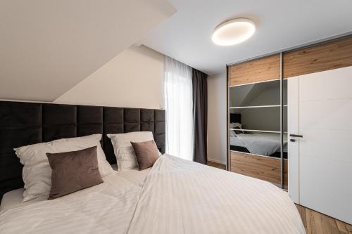 a bedroom with a large bed with a black headboard at Villa Lilien Residence Tatry in Veľká Lomnica