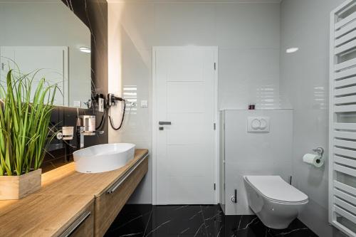 a white bathroom with a sink and a toilet at Villa Lilien Residence Tatry in Veľká Lomnica