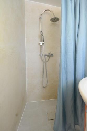 a shower with a blue shower curtain in a bathroom at Chatka in Stegienka