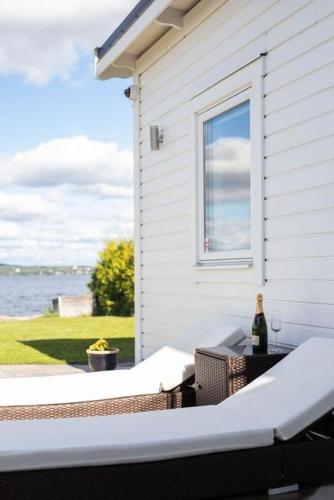 a patio with a bottle of wine and a window at Udden in Herräng