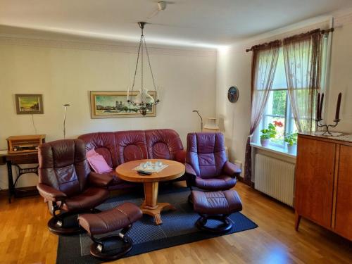 a living room with a couch and chairs and a table at Huset Solhem in Resta