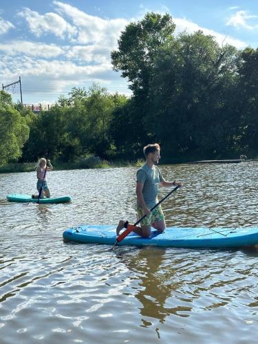 two people on paddle boards on a lake at Čerčanská Koupadla - glampingové stany in Benešov