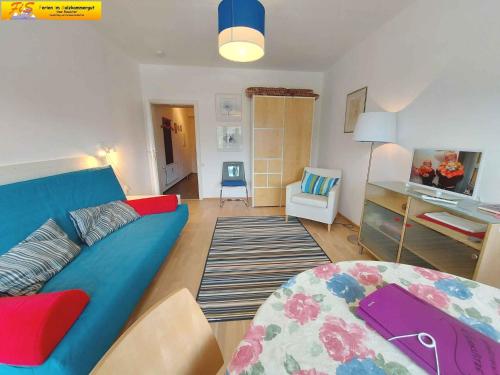 a living room with a blue couch and a table at Studio in Sonnenalm - Salzkammergut 37033 in Reith