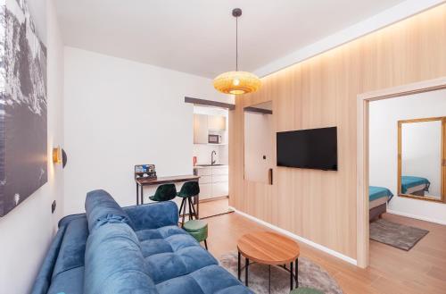a living room with a blue couch and a tv at Mare & Monti in Mlini