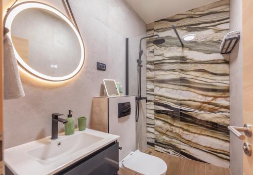a bathroom with a sink and a shower with a refrigerator at Mare & Monti in Mlini