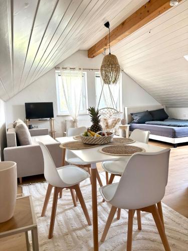 una sala de estar con una mesa, sillas y un sofá en Boho Style Apartment mit Stellplatz, en Memmingen