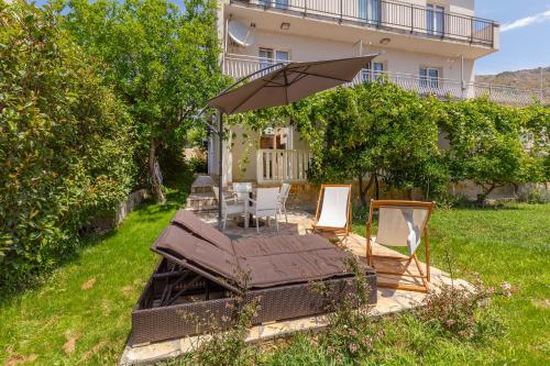 a patio with an umbrella and a table and chairs at Mare & Monti in Mlini