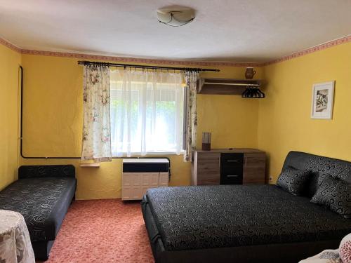 a living room with a couch and a window at Aranyhal Vendégház in Poroszló