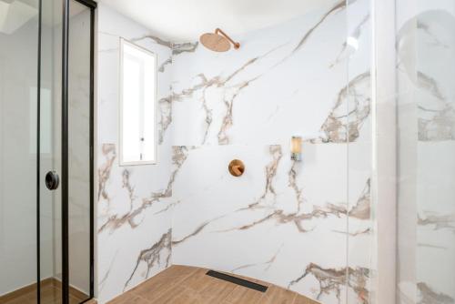 a bathroom with marble walls and a shower at CH105 Poblado 7BR Villa Jacuzzi AC 24 hours Security in Medellín
