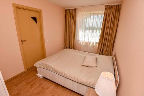 a small bedroom with a bed and a window at Baltic Apartment in Klaipėda