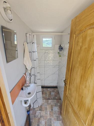 a bathroom with a sink and a shower at Complex CRAI Varciorog in Vîrciorog