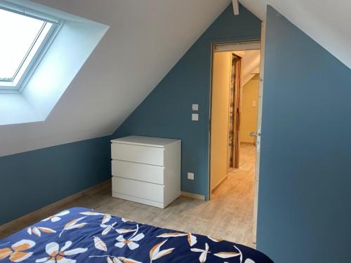 a bedroom with blue walls and a bed with a dresser at La maison à Nono in La Trinité