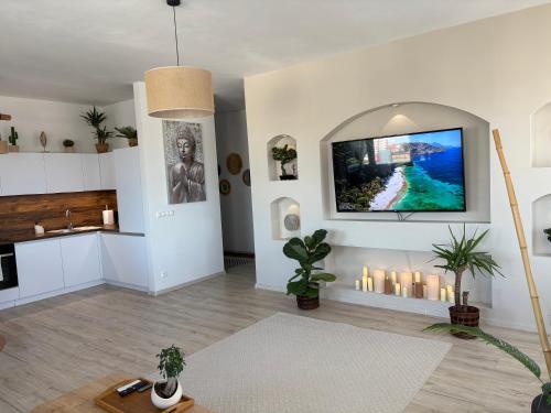 a living room with candles and a tv on the wall at Oáza Apartmán in Poprad