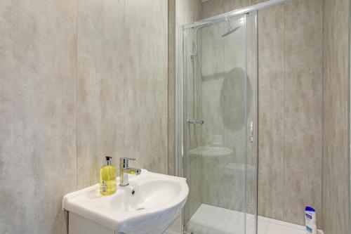 un baño con lavabo y ducha en Luxury 5-bedroom home in Newcastle, en Longbenton