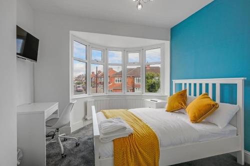 Un dormitorio con una cama y un escritorio y una ventana. en Luxury 5-bedroom home in Newcastle, en Longbenton