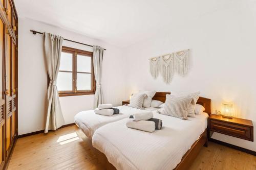 2 bedden in een slaapkamer met witte muren en een raam bij El Nido Seafront Hideaway by Bayside in Playa Honda