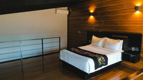 a bedroom with a bed with a wooden wall at Origen75 Loft - Villas - Skypool - Viñedo, Valle de Guadalupe in Valle de Guadalupe