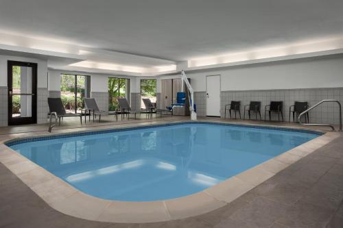 a large blue swimming pool with chairs and tables at Courtyard by Marriott Colorado Springs South in Colorado Springs