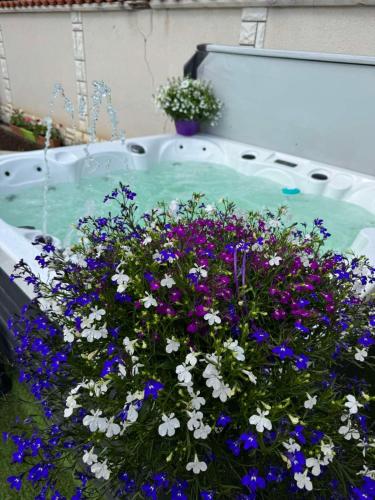 a bunch of purple and white flowers in a tub at Къща за гости Заркови in Gaber