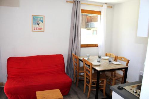 une salle à manger avec une chaise rouge et une table dans l'établissement Les Chalets De Superd Heliantheme - 2 Pièces pour 4 Personnes MAE-8744, à Saint-Étienne-en-Dévoluy