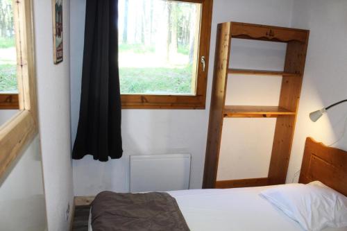 une petite chambre avec un lit et une fenêtre dans l'établissement Les Chalets De Superd Heliantheme - 2 Pièces pour 4 Personnes MAE-8744, à Saint-Étienne-en-Dévoluy