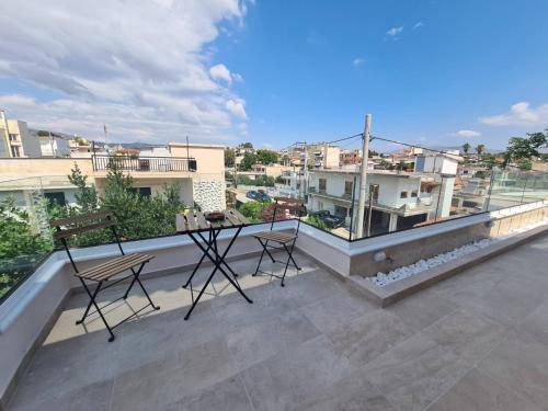 a balcony with two chairs and a table on the roof at IVory Suites near Athens Airport in Spáta