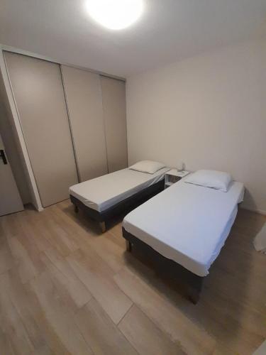 - 2 lits dans une petite chambre dotée de parquet dans l'établissement Maison Almanarre, à Hyères