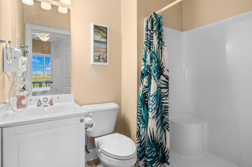 a bathroom with a toilet and a sink and a shower curtain at ONE More Cherry on Top - 5BR-4BA Marshfront- Heated Pool, Hot Tub, Elevator, Sleeps 14 in Myrtle Beach