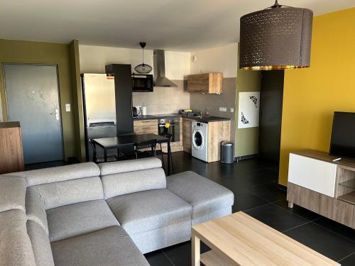 un salon avec un canapé et une cuisine dans l'établissement Ajaccio j2, à Ajaccio