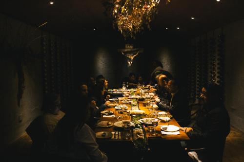 a group of people sitting at a long table at Origen75 Loft - Villas - Skypool - Viñedo, Valle de Guadalupe in Valle de Guadalupe