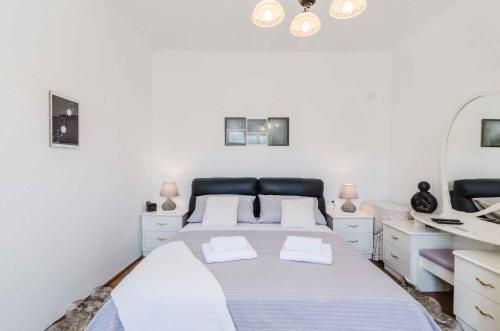 a white bedroom with a large bed with two pillows at Holiday home in Drivenik 39517 in Drivenik