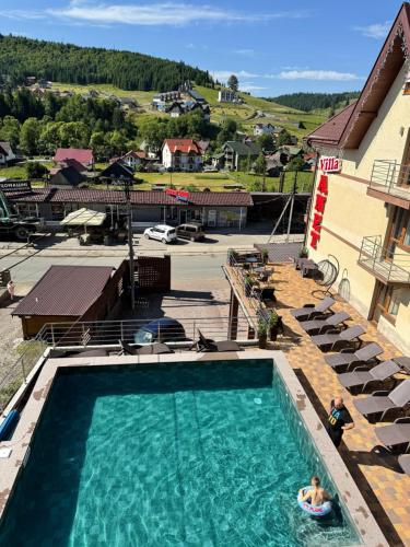 una persona seduta in una piscina in un hotel di Villa Anet a Bukovel