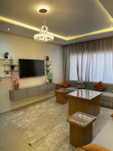a living room with a couch and a tv at Panoramic Family Apartment Agadir New in Agadir
