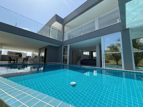a house with a swimming pool in front of it at Riviera dourada - Casa Pôr do Sol in Jacumã