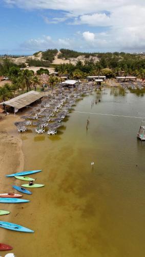 a beach with chairs and surfboards in the water at Riviera dourada - Casa Pôr do Sol in Jacumã