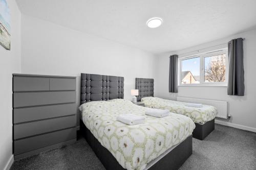 a bedroom with two twin beds and a window at 3BDR Gated parking near city centre in Manchester