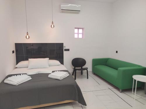 a bedroom with a bed and a green couch at Roxanne Mini Suite With Yard in Melíssia