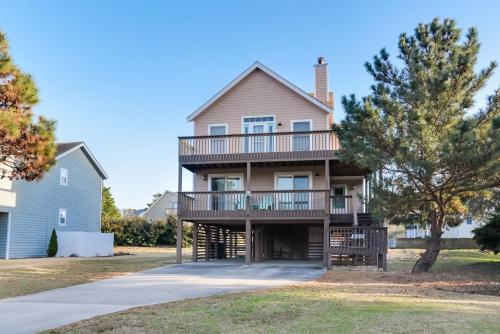 a house with a wrap around porch with a deck at Finn Tales in Nags Head