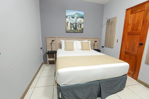a bedroom with a large bed in a room at Hotel Los Altos Express "La Centroamerica" in Managua