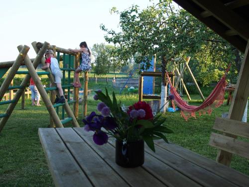 una mesa con un jarrón de flores en un parque infantil en Agroturystyka Lolkowo, en Srokowo