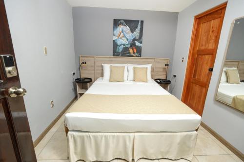 a bedroom with a large bed in a room at Hotel Los Altos Express "La Centroamerica" in Managua