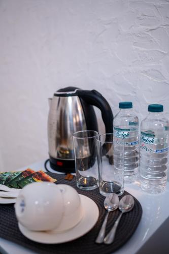 a table with a tea kettle and glasses of water at Livada in Gonio