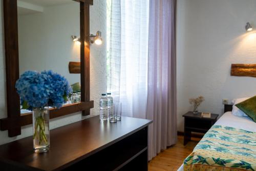 a bedroom with a vase of blue flowers on a table at Livada in Gonio